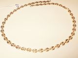 a close up of a gold chain necklace on a white surface