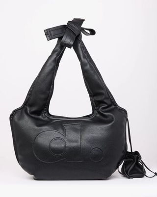 a black leather bag with a bow on the handle