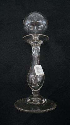 une image représentant un bougeoir en verre sur fond noir