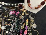 many different necklaces and bracelets displayed on a table
