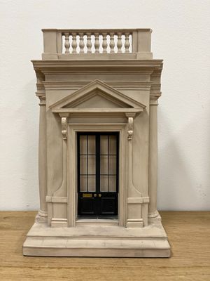 a small model of a building on a wooden table