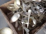 a lot of silver spoons and forks in a box