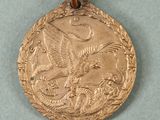 an image of a gold medal with a bird on it