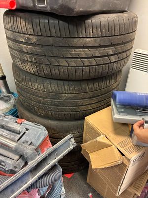une femme qui travaille sur un ordinateur portable près d'un tas de pneus