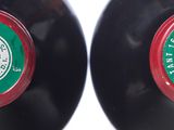 two black vinyl records with green and red labels sitting on top of each other