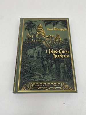 un vieux livre posé sur une surface blanche, avec une image de château en arrière-plan