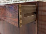 a close up of a wooden dresser with a drawer in it