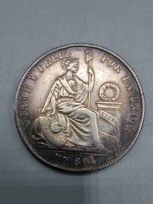 une vieille pièce de monnaie sur laquelle est assise une femme