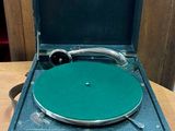 un tourne-disque posé dans une valise sur une table