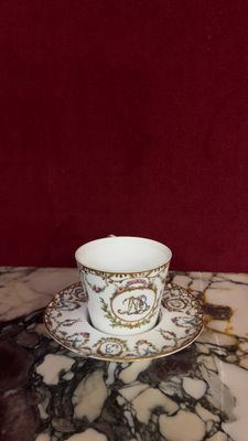 a cup and saucer sitting on a marble table