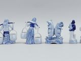 six blue and white figurines of people with buckets