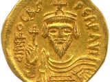 a close up of a gold coin on a white surface