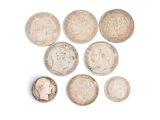 six types différents de pièces d'argent sur une surface blanche