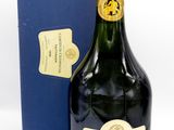 une image représentant une bouteille de champagne à côté d'une boîte bleue