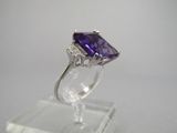 une bague en améthorate et diamant exposée sur un socle transparent