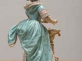a figurine of a woman sitting on a table