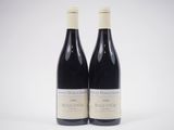 deux bouteilles de vin rouge posées l'une à côté de l'autre sur une surface blanche