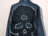 the back of a denim jacket with a skull on it