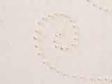 a close up of a white wall with pearls on it
