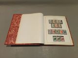 an open book with stamps on it sitting on a table