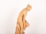 statue of a man leaning on his knees on a marble base