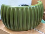a green vase sitting on top of a cardboard box