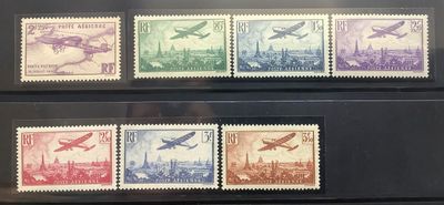 three stamps of different colors are on display in a glass case