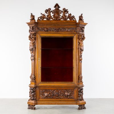 une vitrine ancienne en bois recouverte de velours rouge