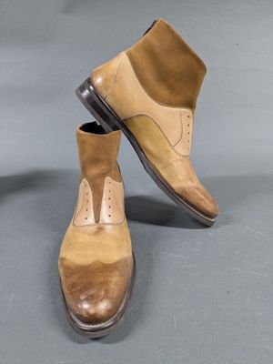 pair of men ' s tan and brown leather shoes on a gray surface