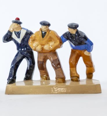trois figurines représentant des hommes debout sur un socle en bois