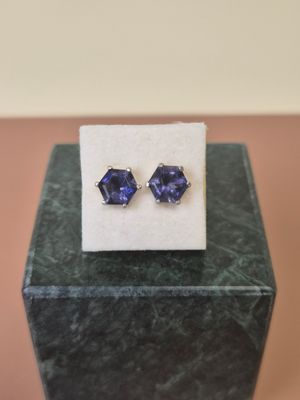 a pair of blue sapphire earrings sitting on top of a marble block