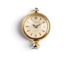 a small gold clock with a bell hanging from it ' s side