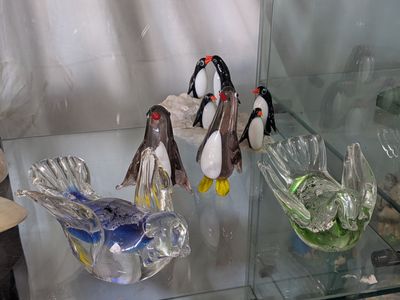 a glass display case with glass penguins on it