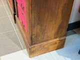 une armoire en bois surmontée d'un couvercle rose