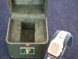 a watch and a watch box on a blue carpet