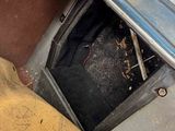 a dirty car with the door open in the back of the car