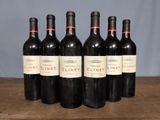 six bottles of wine are lined up on a wooden table