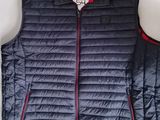 Le gilet est bleu et comporte une fermeture éclair rouge sur le devant.