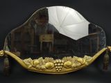 un miroir avec un cadre doré et un parapluie blanc