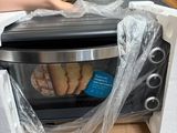 a person holding a bag over a toaster oven in a box