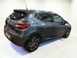 the rear end of a grey car in a white room