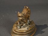 bronze figurine of a dog on a pedestal on a table