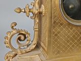 a gold clock that is sitting on a table