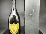 une bouteille de champagne posée sur une table à côté d'un coffret
