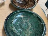 two plates sitting on a table with a chair in the background
