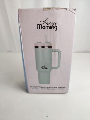 emballage d'un mug « café vert » dans une boîte rose posée sur une surface blanche