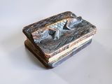 une image représentant une petite boîte en bois sur laquelle figure un oiseau