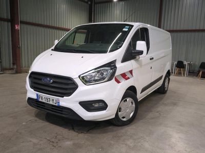 La camionnette blanche est garée à l'intérieur d'un bâtiment, dans un entrepôt.