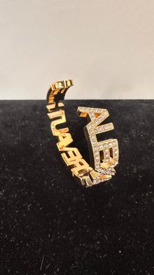 a close up of a gold and diamond ring on a black velvet surface