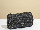 un sac Chanel noir posé sur une table blanche